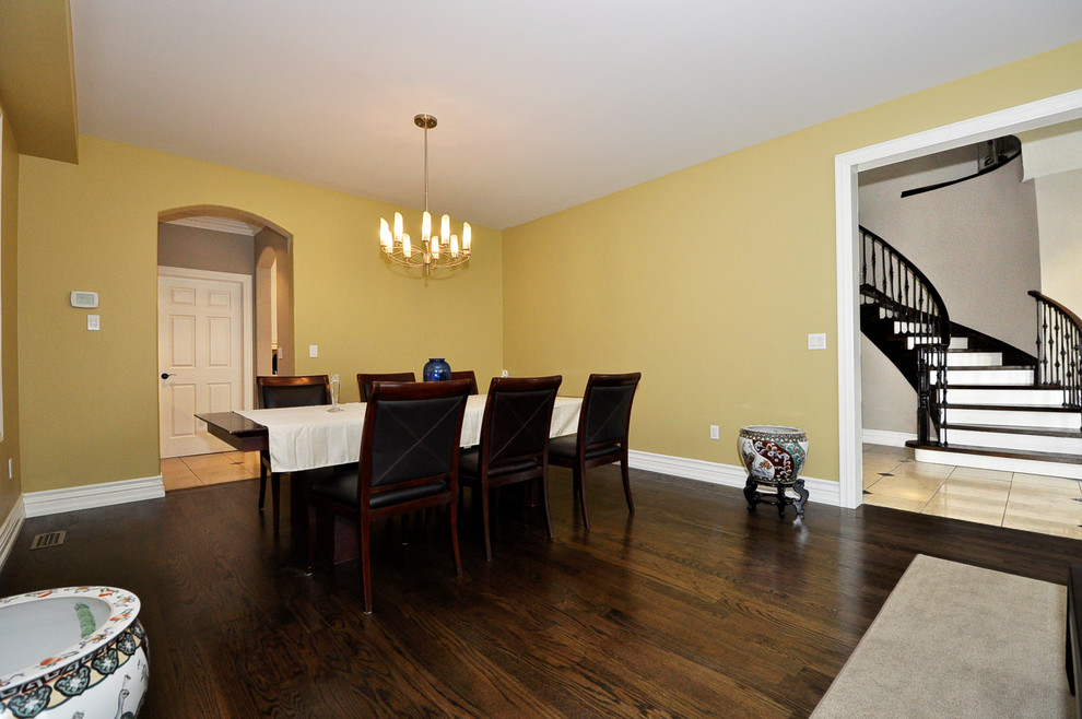 Example of a large classic dark wood floor and brown floor dining room design in Toronto with beige walls and no fireplace