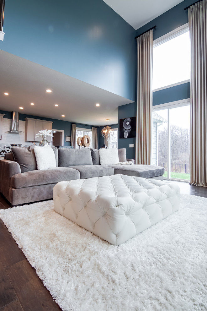 Immagine di un soggiorno tradizionale con pareti blu e TV a parete