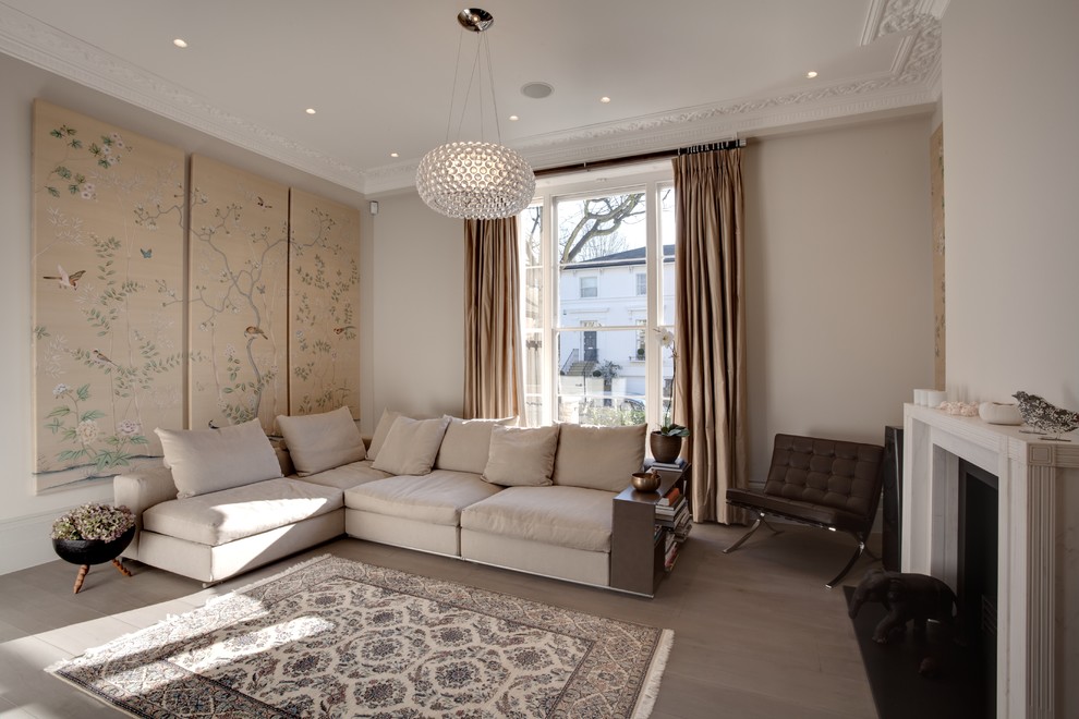 Пример оригинального дизайна: гостиная комната в стиле неоклассика (современная классика) с бежевыми стенами и стандартным камином