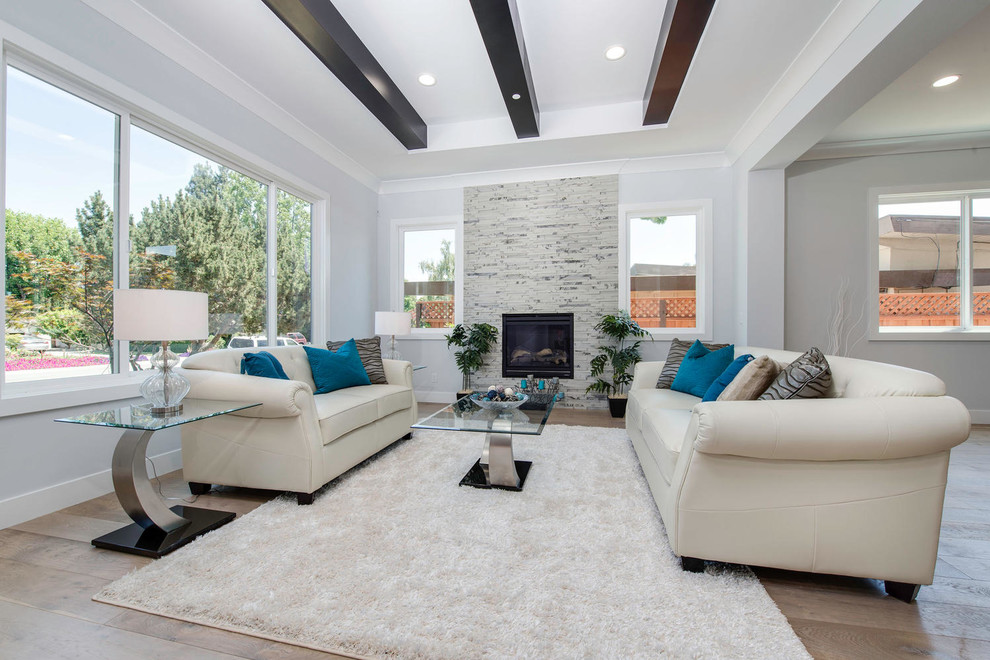 Inspiration for a large transitional formal and open concept light wood floor living room remodel in San Francisco with white walls, a hanging fireplace, a stone fireplace and no tv