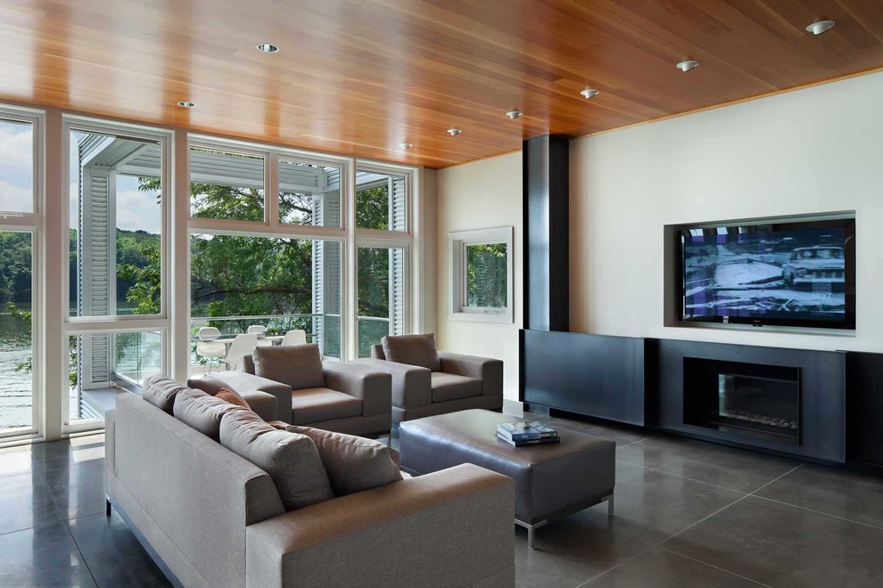 На фото: открытая, парадная гостиная комната среднего размера в стиле модернизм с белыми стенами, бетонным полом, стандартным камином, фасадом камина из металла, телевизором на стене и серым полом