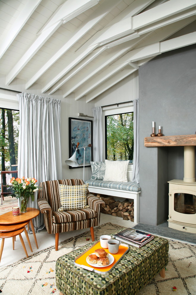 Immagine di un soggiorno bohémian con pareti bianche, stufa a legna e nessuna TV