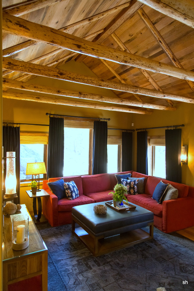 На фото: маленькая изолированная гостиная комната в стиле рустика с паркетным полом среднего тона, двусторонним камином, фасадом камина из камня и телевизором на стене для на участке и в саду