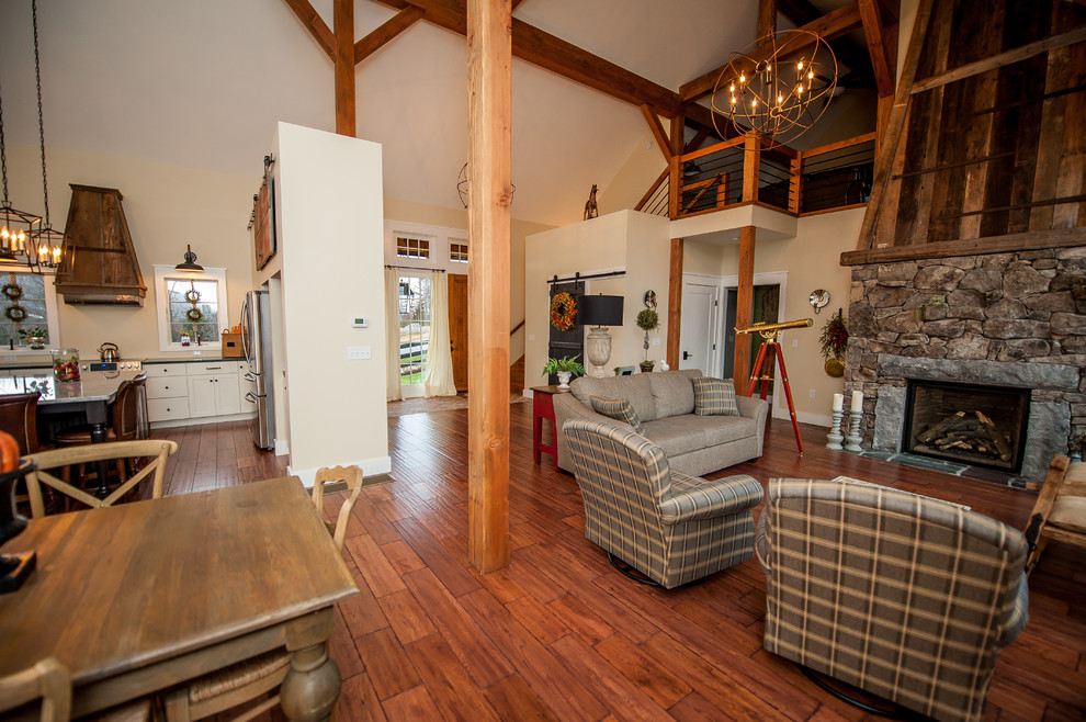 Ejemplo de salón abierto ecléctico grande con paredes blancas, suelo de madera en tonos medios, todas las chimeneas y marco de chimenea de piedra