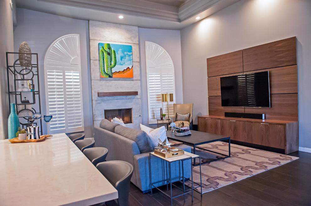 Example of a large minimalist formal and open concept dark wood floor living room design in Phoenix with gray walls, a standard fireplace, a concrete fireplace and a media wall