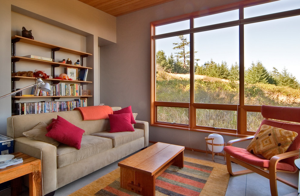 Idées déco pour un petit salon moderne ouvert avec sol en béton ciré, une bibliothèque ou un coin lecture et un mur gris.