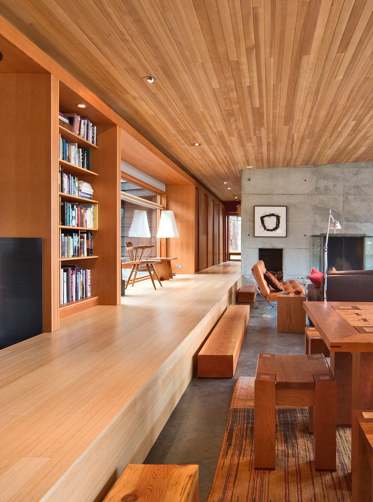 Idée de décoration pour un petit salon minimaliste ouvert avec un mur multicolore, parquet en bambou, une cheminée standard et un manteau de cheminée en béton.