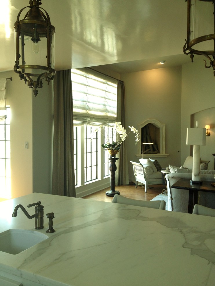 Offenes Klassisches Wohnzimmer mit weißer Wandfarbe, dunklem Holzboden, Eckkamin und Kaminumrandung aus Stein in Houston