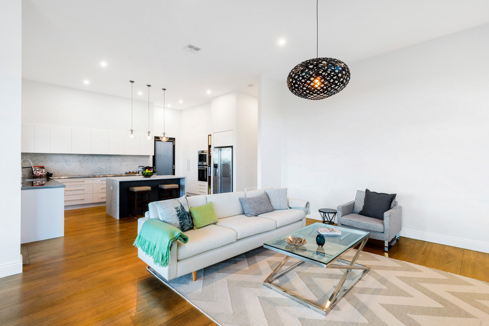 Mittelgroßes, Offenes Modernes Wohnzimmer mit weißer Wandfarbe und braunem Holzboden in Melbourne