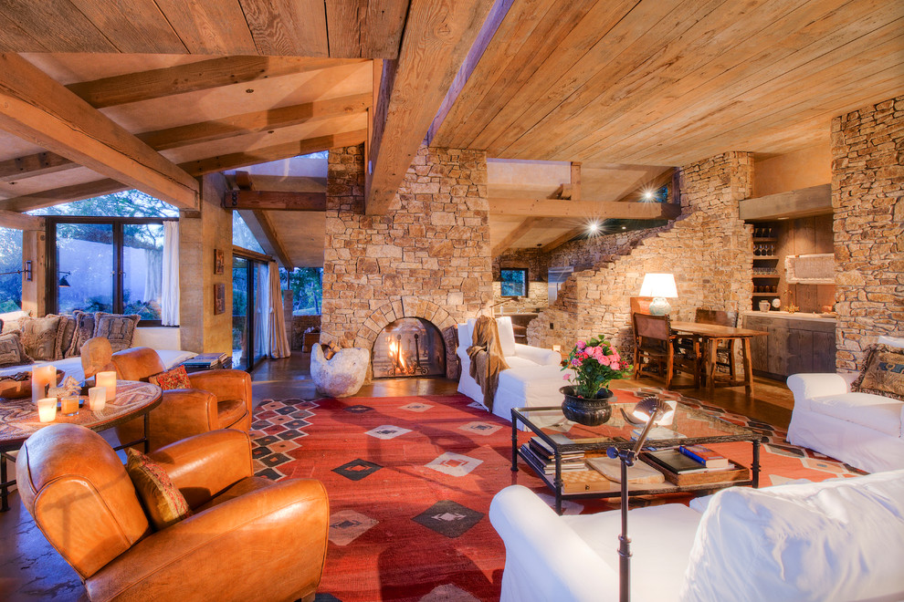 Diseño de salón abierto mediterráneo extra grande con paredes beige, suelo de madera clara, chimenea de doble cara y marco de chimenea de piedra