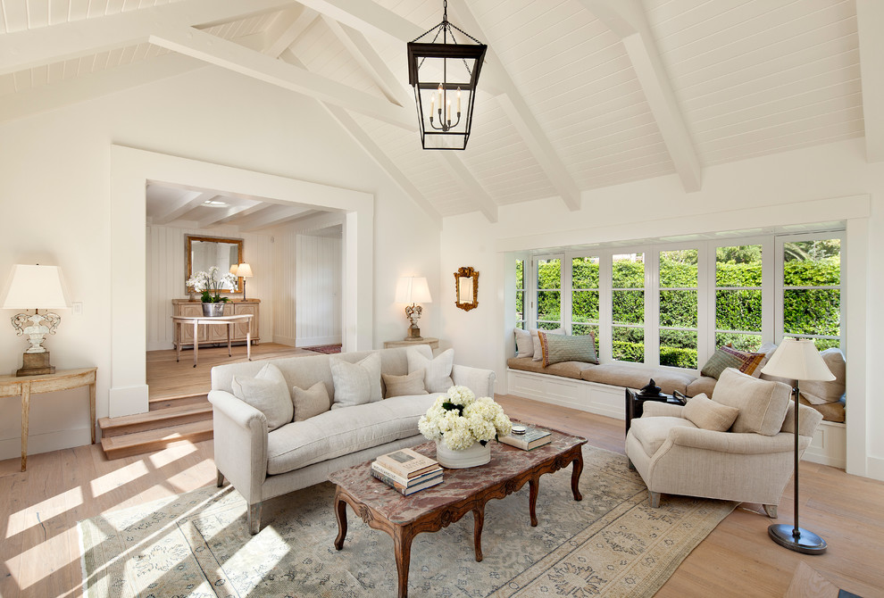 Abgetrenntes Landhaus Wohnzimmer mit weißer Wandfarbe und hellem Holzboden in Santa Barbara