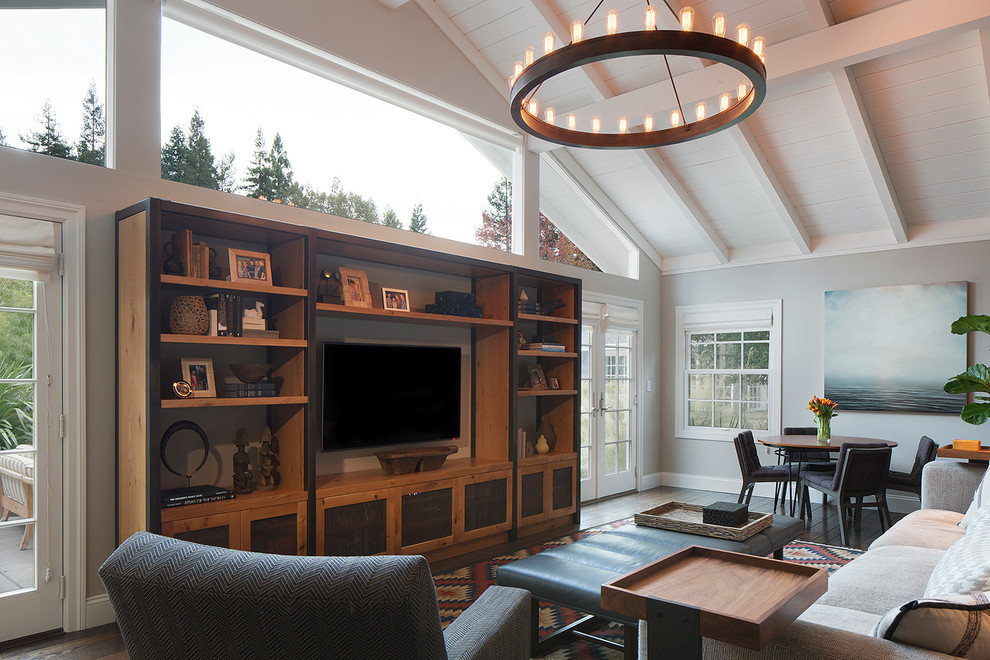 Cette photo montre un salon tendance de taille moyenne avec un mur gris, parquet foncé, un téléviseur encastré et un sol marron.