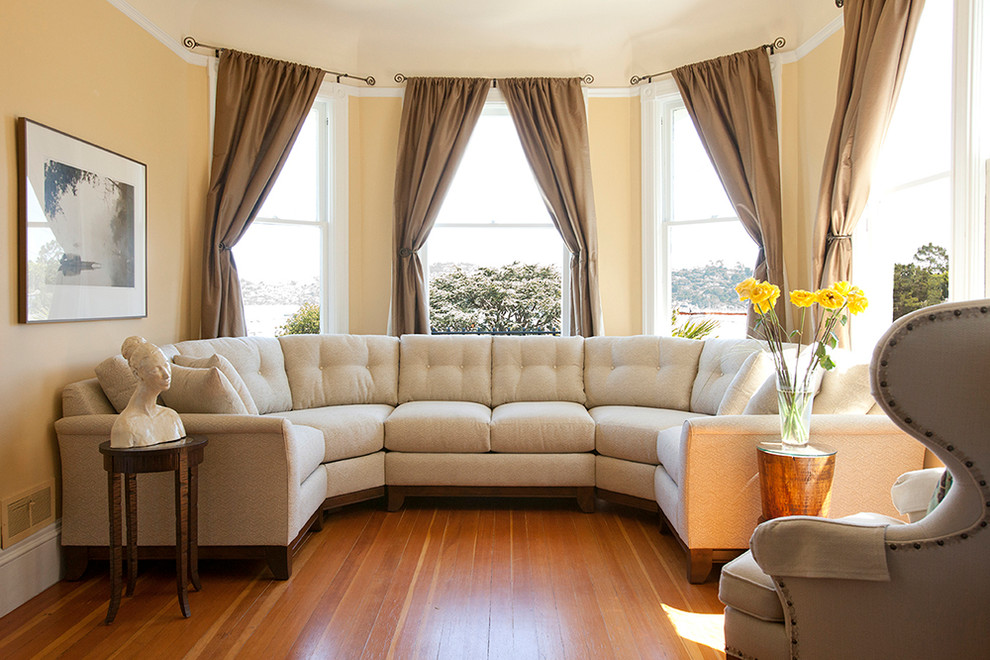На фото: парадная, изолированная гостиная комната среднего размера в стиле неоклассика (современная классика) с желтыми стенами, паркетным полом среднего тона и коричневым полом без камина
