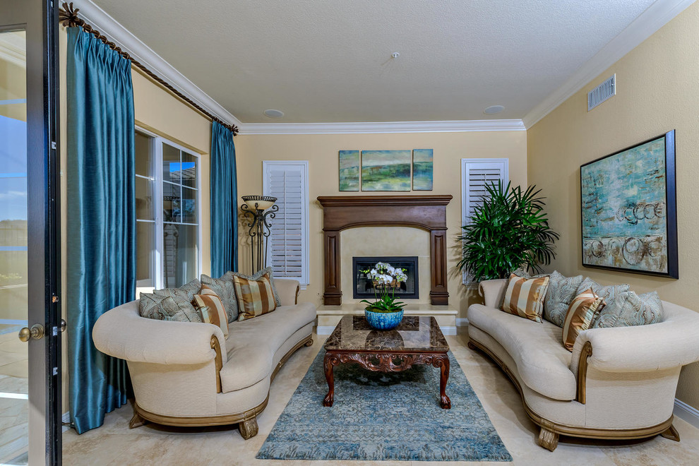 Mittelgroßes, Repräsentatives Klassisches Wohnzimmer mit beiger Wandfarbe, Travertin, Kamin, Kaminumrandung aus Stein und beigem Boden in Orange County