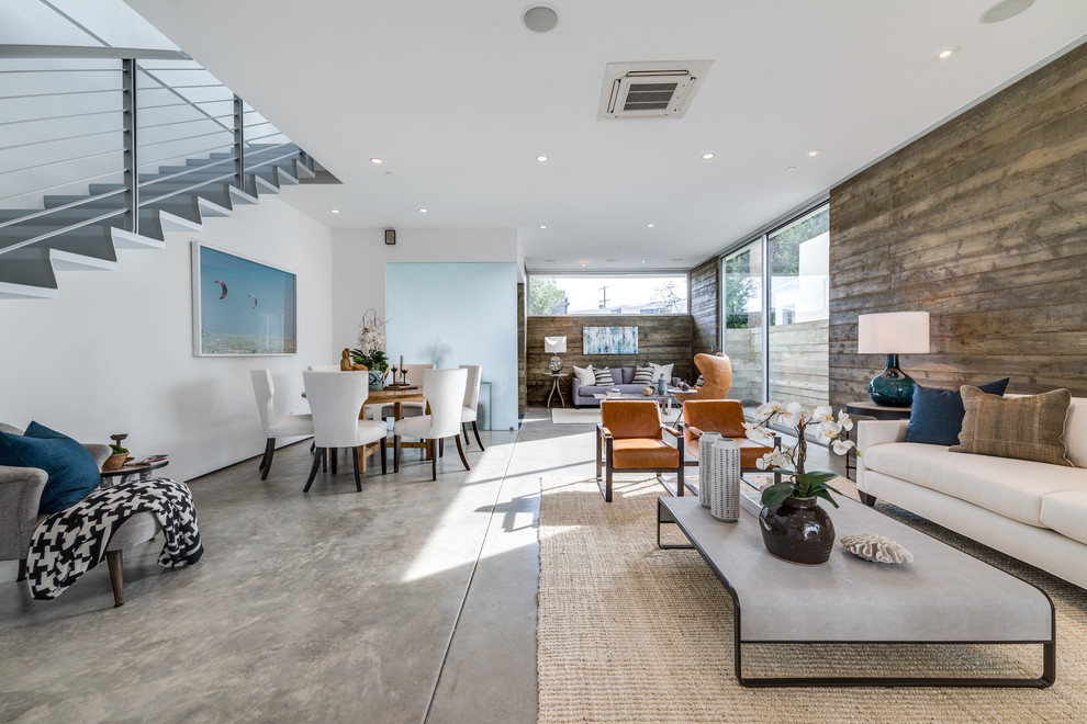 Immagine di un soggiorno design di medie dimensioni e aperto con pareti bianche, pavimento in cemento, nessuna TV e pavimento grigio