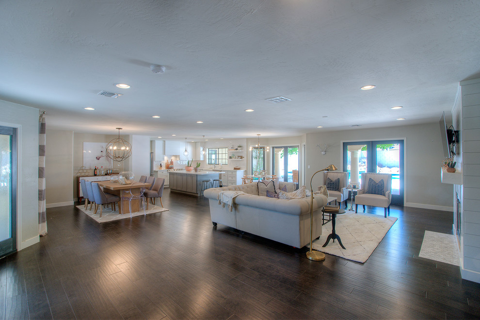 Mittelgroßes, Offenes Modernes Wohnzimmer mit beiger Wandfarbe, dunklem Holzboden, Kamin, TV-Wand und braunem Boden in Phoenix