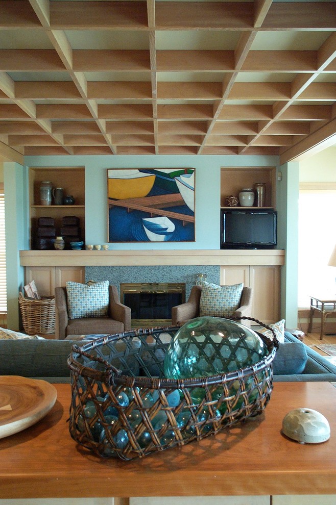 Foto de salón abierto marinero de tamaño medio con paredes azules, suelo de madera clara, todas las chimeneas, marco de chimenea de hormigón y pared multimedia