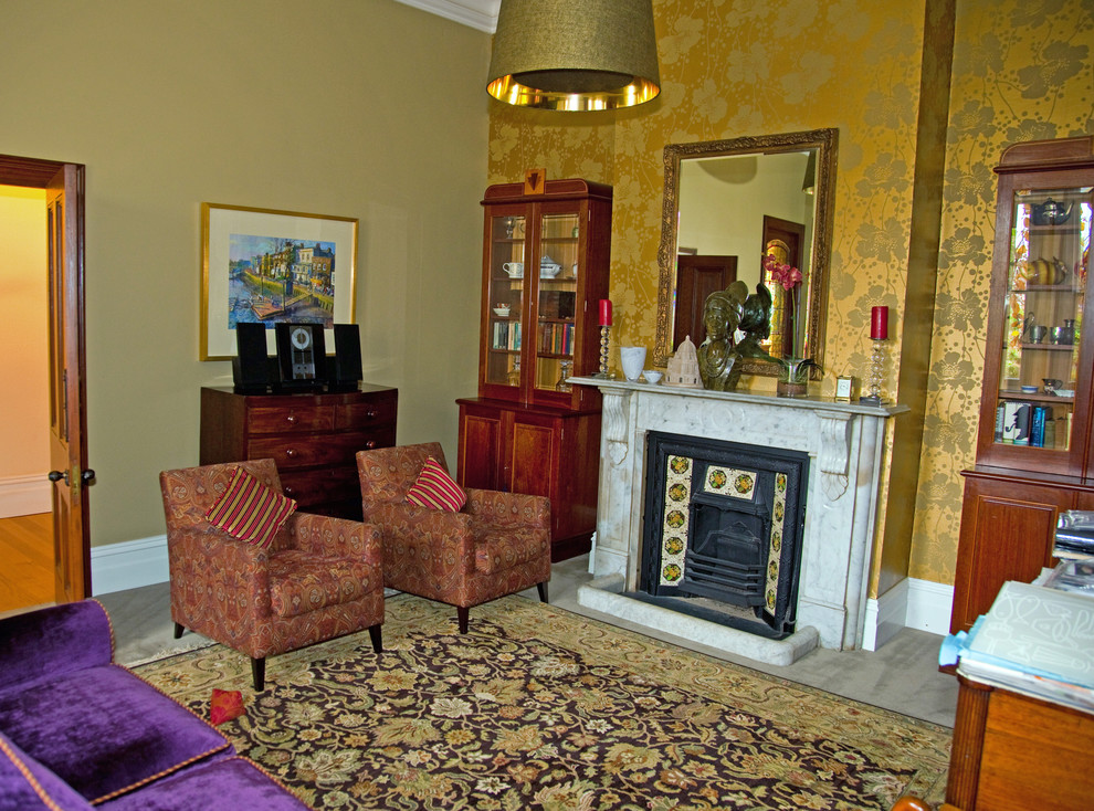 Exempel på ett mellanstort klassiskt separat vardagsrum, med gula väggar, heltäckningsmatta, en standard öppen spis och en spiselkrans i sten