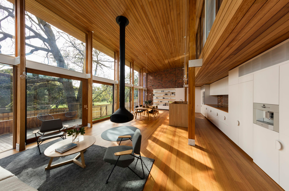 Idéer för ett stort modernt vardagsrum, med mellanmörkt trägolv, brunt golv och en hängande öppen spis