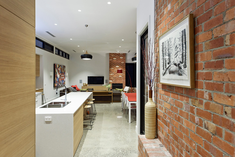 Immagine di un grande soggiorno contemporaneo aperto con pareti bianche, pavimento in cemento, camino classico, cornice del camino in mattoni e TV a parete