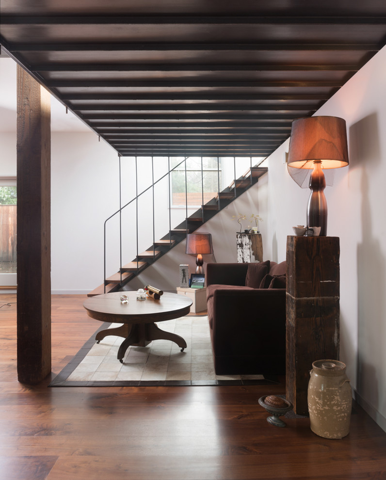 На фото: открытая гостиная комната среднего размера в стиле модернизм с коричневым диваном без телевизора