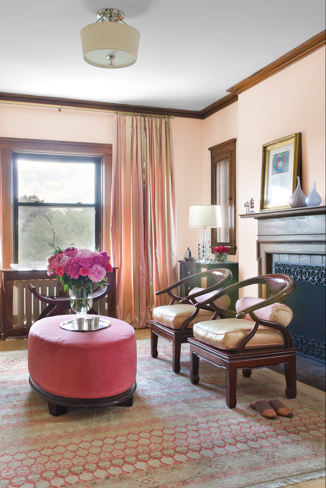 Klassisk inredning av ett vardagsrum, med rosa väggar och en standard öppen spis