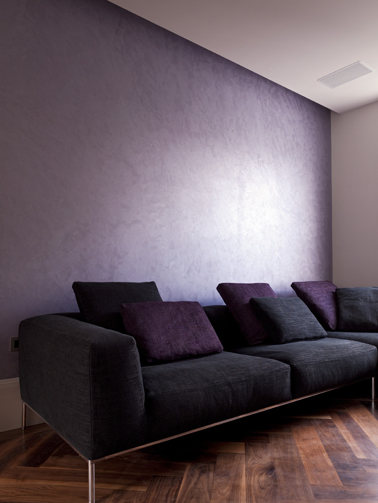 На фото: открытая гостиная комната среднего размера в современном стиле с фиолетовыми стенами, темным паркетным полом и мультимедийным центром без камина