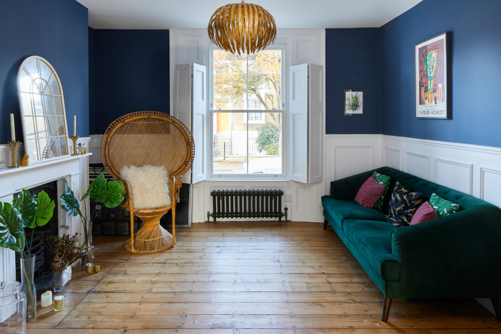 Klassisches Wohnzimmer mit blauer Wandfarbe, braunem Holzboden, Kamin, braunem Boden und vertäfelten Wänden in London