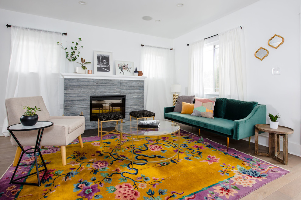 Abgetrenntes, Großes, Fernseherloses Stilmix Wohnzimmer mit weißer Wandfarbe, Kamin, Kaminumrandung aus Stein, braunem Holzboden und braunem Boden in Los Angeles