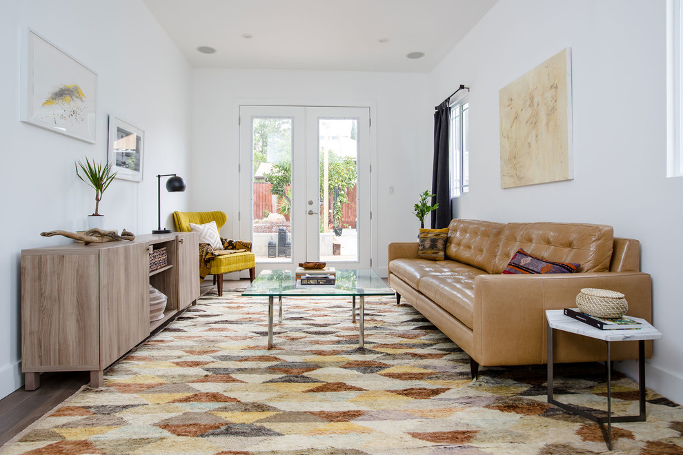 Ispirazione per un soggiorno design chiuso con pareti bianche, pavimento in legno massello medio e nessun camino