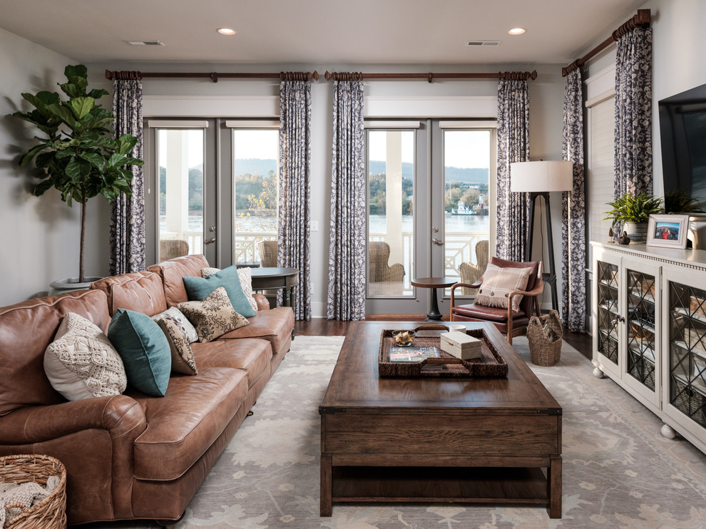 Immagine di un soggiorno chic di medie dimensioni e aperto con pareti grigie, pavimento in legno massello medio, TV a parete e pavimento marrone