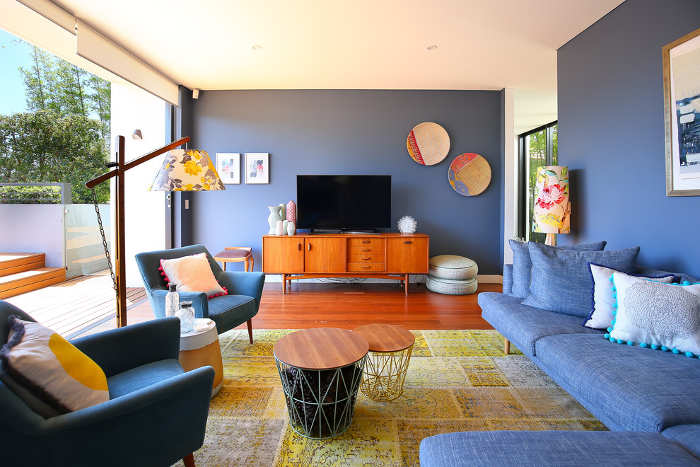 Abgetrenntes Retro Wohnzimmer mit blauer Wandfarbe, braunem Holzboden und freistehendem TV in Sydney
