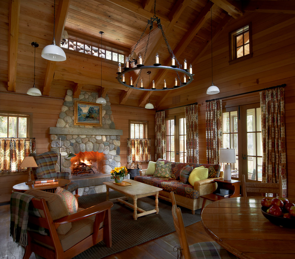 Aménagement d'un salon montagne ouvert avec une salle de réception, un sol en bois brun et une cheminée standard.