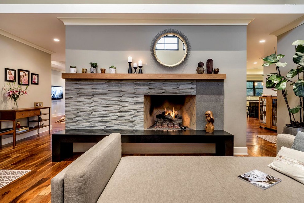 Example of a mid-sized trendy formal and open concept medium tone wood floor living room design in San Francisco with gray walls, a standard fireplace and a stone fireplace