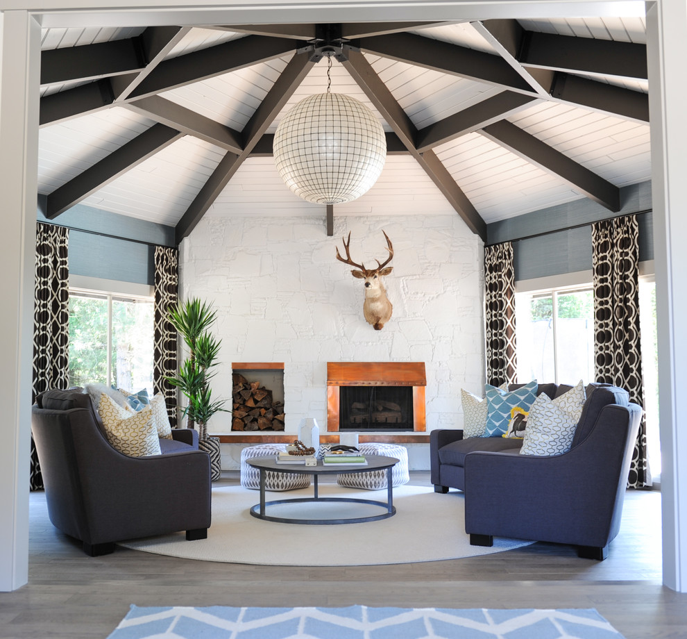 Inspiration for a mid-sized transitional enclosed light wood floor and brown floor living room remodel in Other with a standard fireplace, blue walls, a stone fireplace and no tv