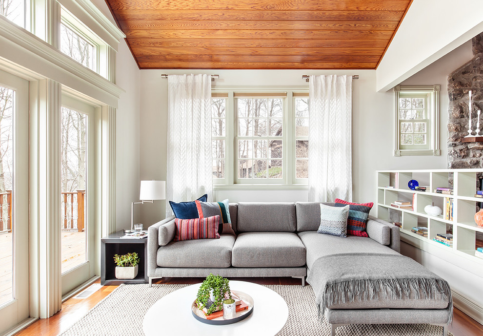 Mittelgroßes, Abgetrenntes Modernes Wohnzimmer mit weißer Wandfarbe, braunem Holzboden, Kamin, Kaminumrandung aus Stein und freistehendem TV in New York