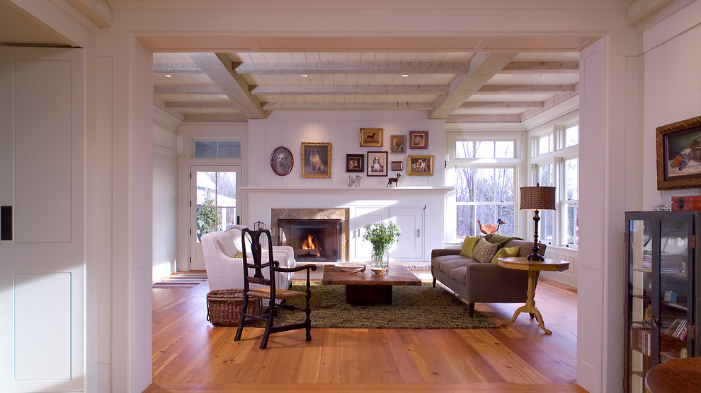 This is an example of a medium sized traditional enclosed living room in Minneapolis with white walls, medium hardwood flooring, a standard fireplace, a tiled fireplace surround, no tv and feature lighting.