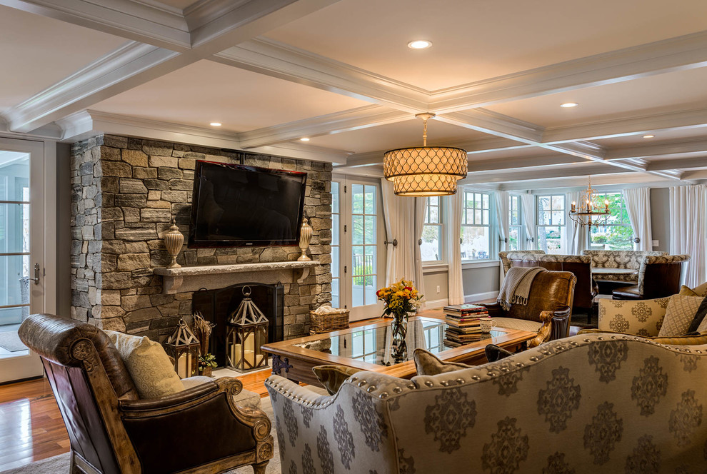 Inspiration for a mid-sized timeless formal and open concept medium tone wood floor living room remodel in Boston with gray walls, a standard fireplace, a stone fireplace and a wall-mounted tv