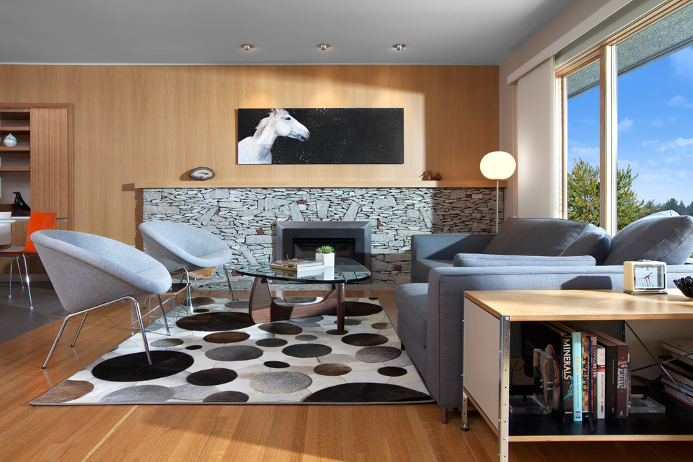 Example of a mid-sized mid-century modern formal and open concept light wood floor and brown floor living room design in Vancouver with a standard fireplace, beige walls, a stone fireplace and no tv
