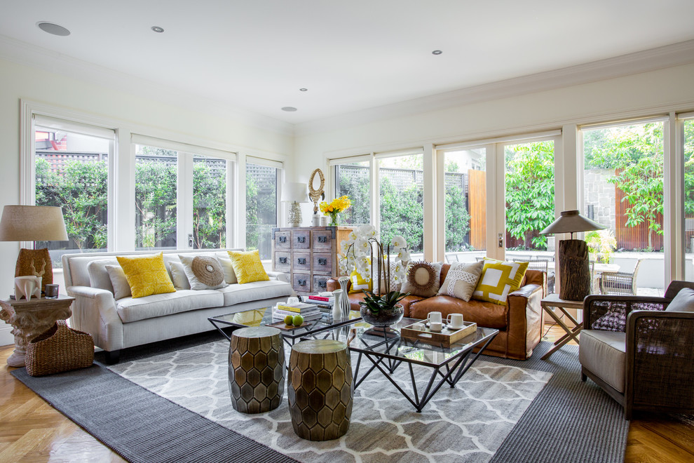 Immagine di un soggiorno stile marinaro di medie dimensioni e aperto con pareti bianche, pavimento in legno massello medio, sala formale e con abbinamento di divani diversi