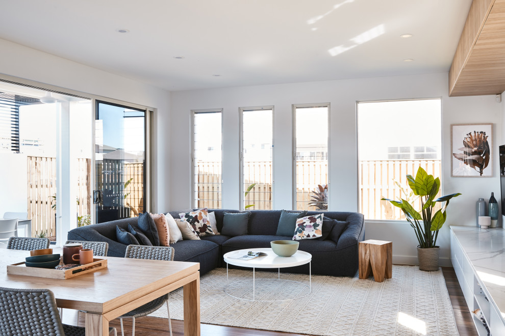 Immagine di un soggiorno design aperto con pareti bianche, parquet scuro e pavimento marrone