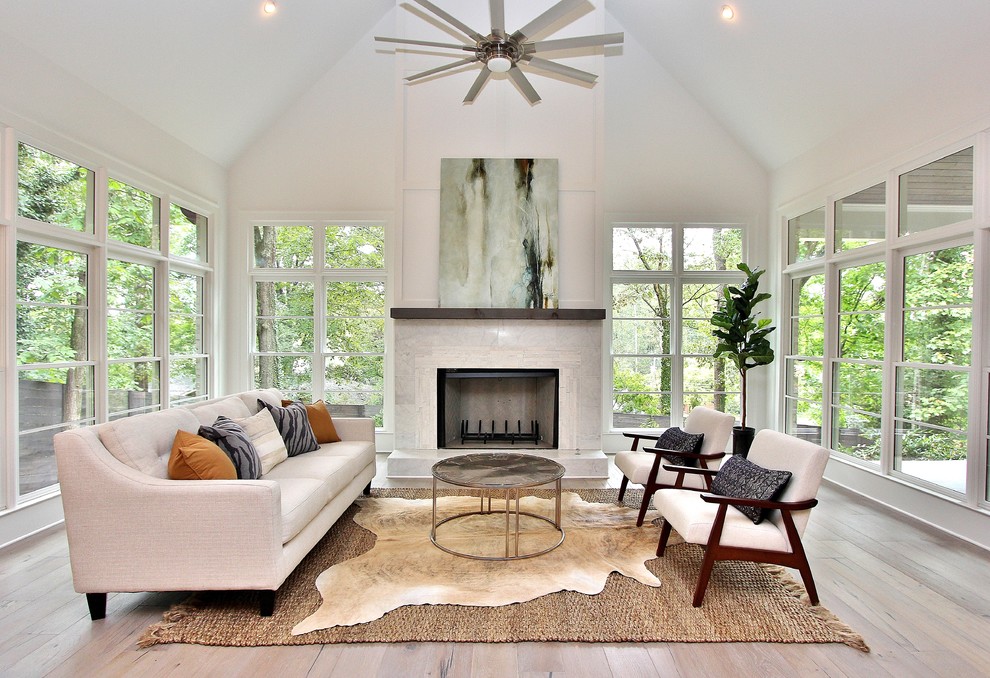 アトランタにあるトランジショナルスタイルのおしゃれな独立型リビング (白い壁、淡色無垢フローリング、標準型暖炉、石材の暖炉まわり、ベージュの床) の写真