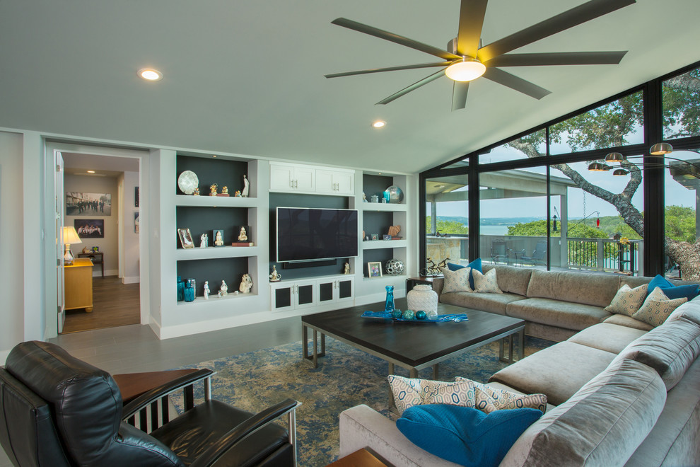 На фото: открытая гостиная комната среднего размера в морском стиле с серыми стенами, полом из керамогранита и телевизором на стене с