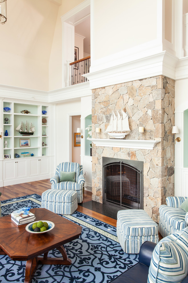 Пример оригинального дизайна: гостиная комната в морском стиле с бежевыми стенами, паркетным полом среднего тона, стандартным камином и фасадом камина из камня