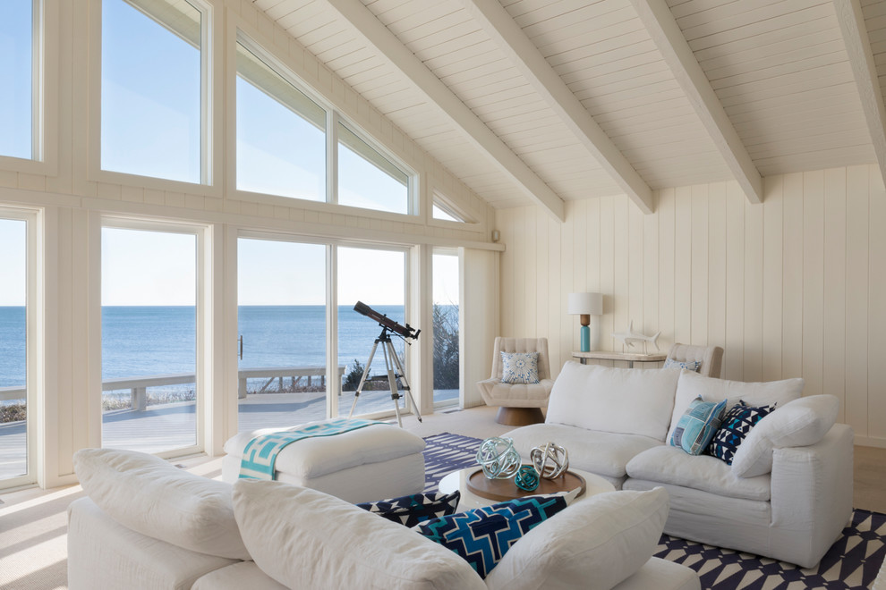 На фото: открытая гостиная комната в морском стиле с белыми стенами, паркетным полом среднего тона и коричневым полом