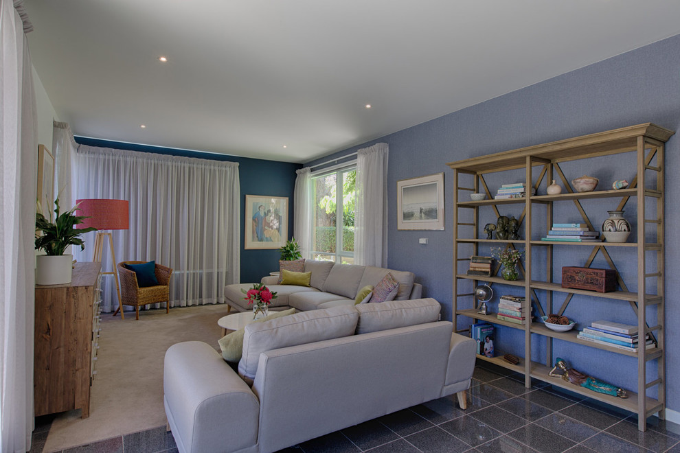 Diseño de salón abierto costero de tamaño medio con paredes azules, moqueta y televisor colgado en la pared
