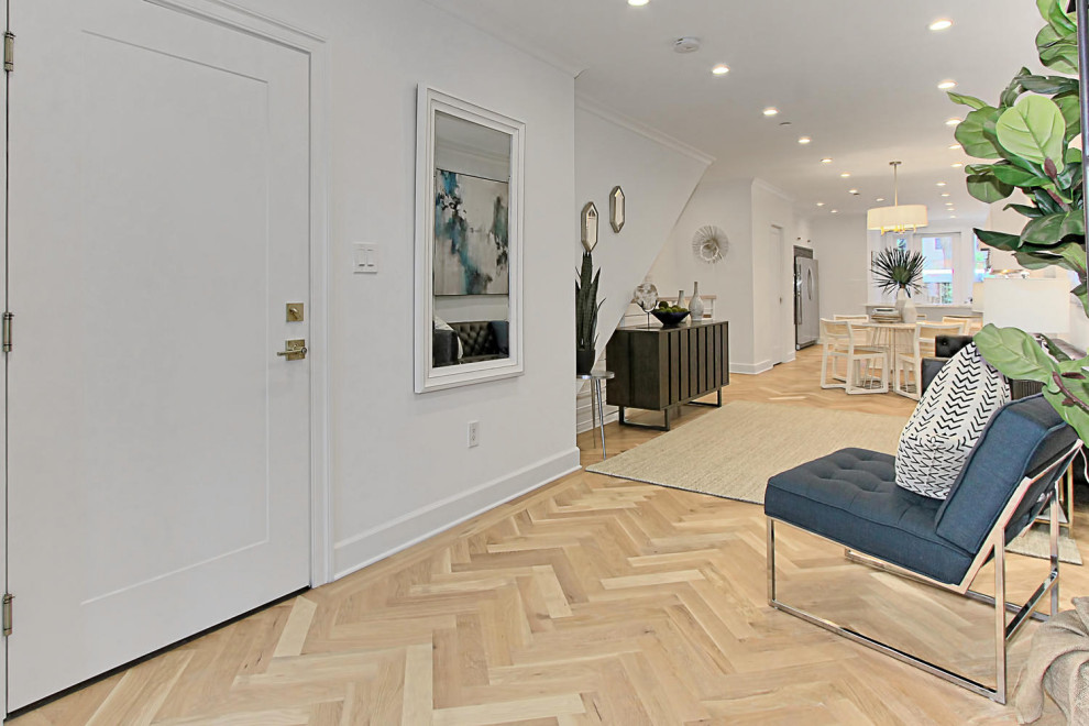 Example of a mid-sized minimalist open concept light wood floor living room design in DC Metro with white walls