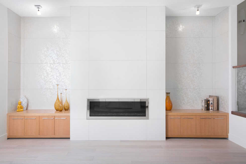 Mittelgroßes, Repräsentatives, Fernseherloses, Offenes Modernes Wohnzimmer mit weißer Wandfarbe, hellem Holzboden, Gaskamin und gefliester Kaminumrandung in Calgary