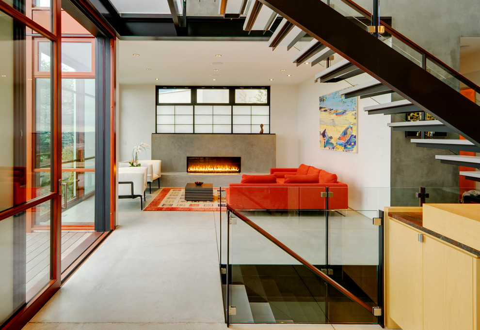 This is an example of a medium sized contemporary formal open plan living room in Seattle with concrete flooring, a ribbon fireplace, white walls, a concrete fireplace surround and no tv.
