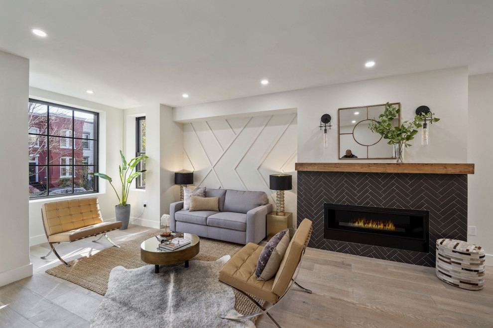 Example of a mid-sized trendy open concept light wood floor and wall paneling living room design in DC Metro with white walls, a standard fireplace and a tile fireplace